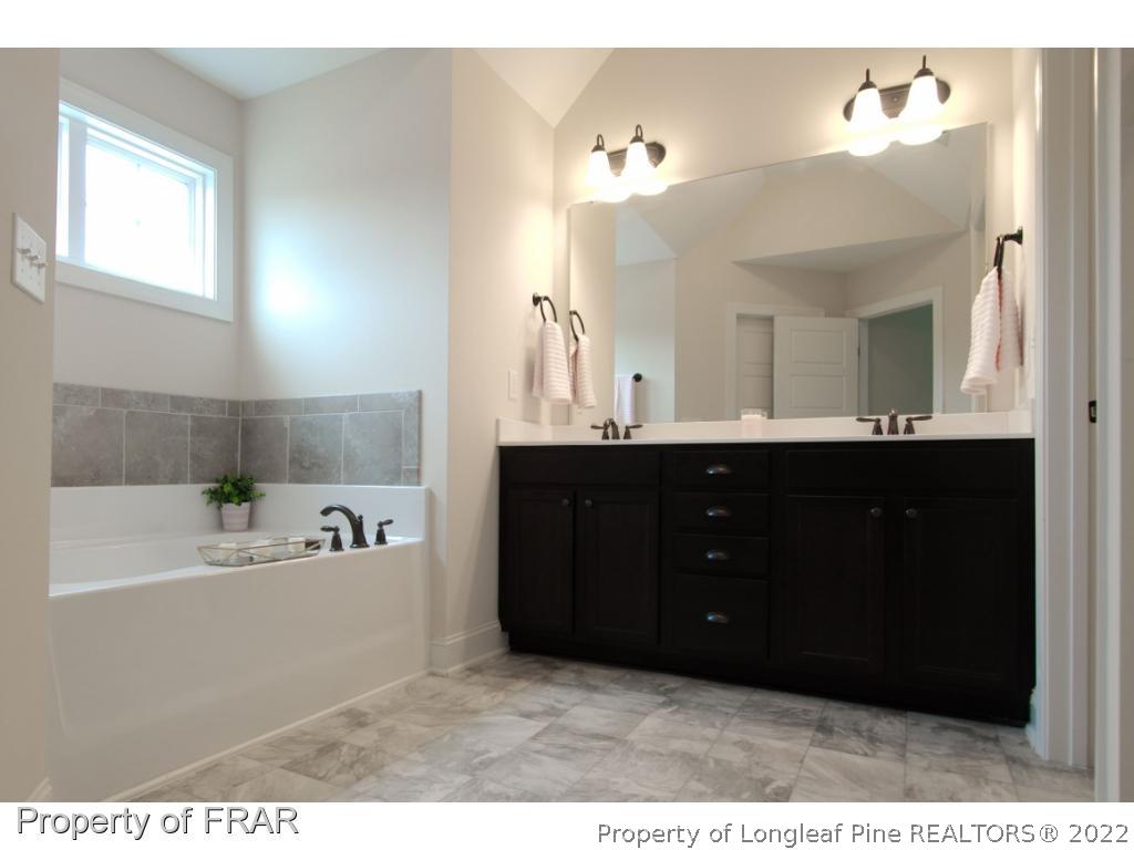 105 Caulfield Road Aberdeen, NC 28315 - Photo 19 of 36 a bathroom with a sink vanity and mirror