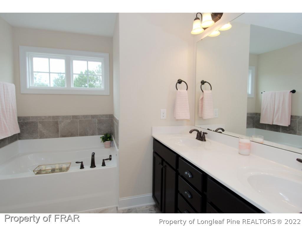 105 Caulfield Road Aberdeen, NC 28315 - Photo 20 of 36 a bathroom with a sink vanity tub and a mirror