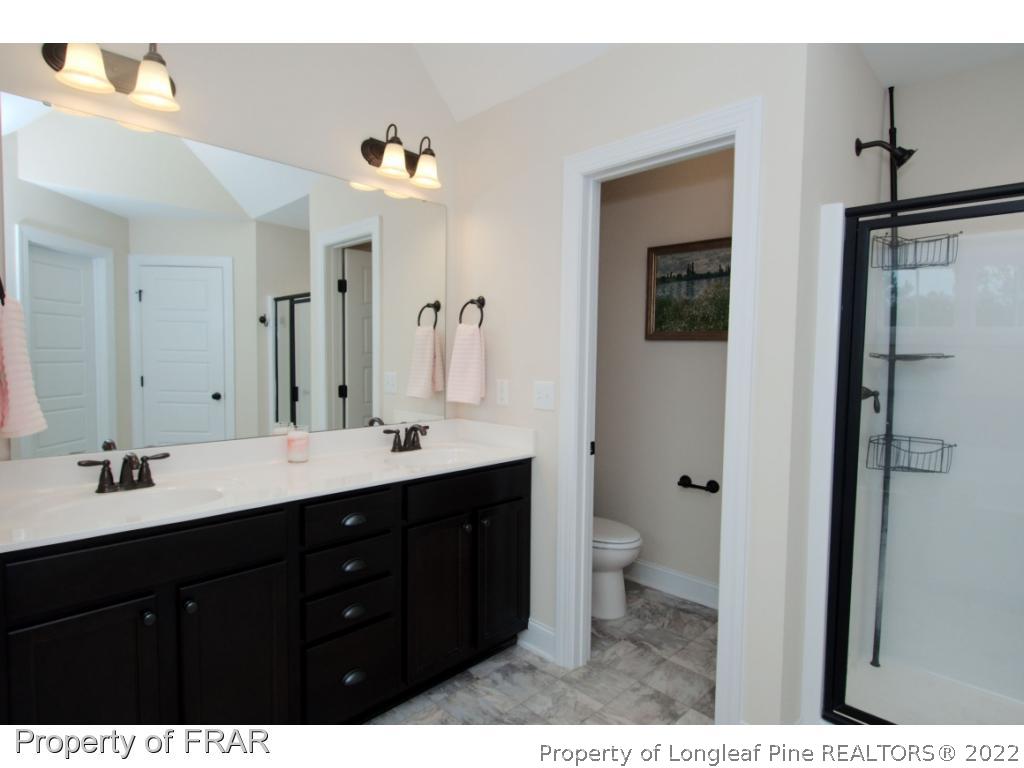 105 Caulfield Road Aberdeen, NC 28315 - Photo 22 of 36 a bathroom with a double vanity sink and mirror with toilet
