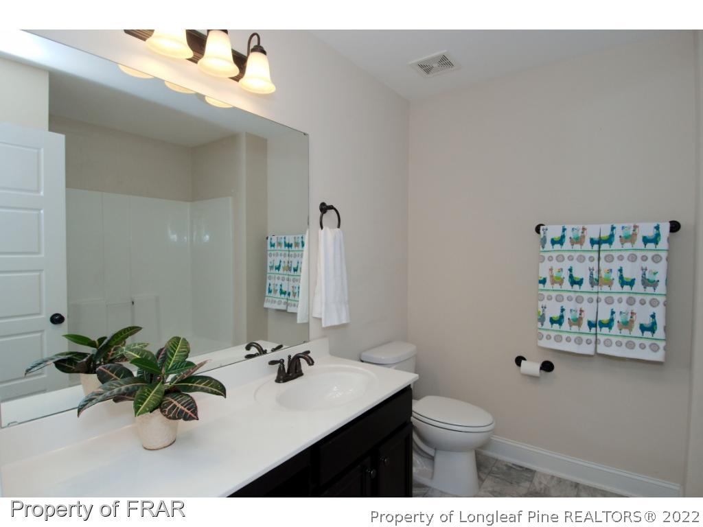105 Caulfield Road Aberdeen, NC 28315 - Photo 28 of 36 a bathroom with a sink mirror and toilet