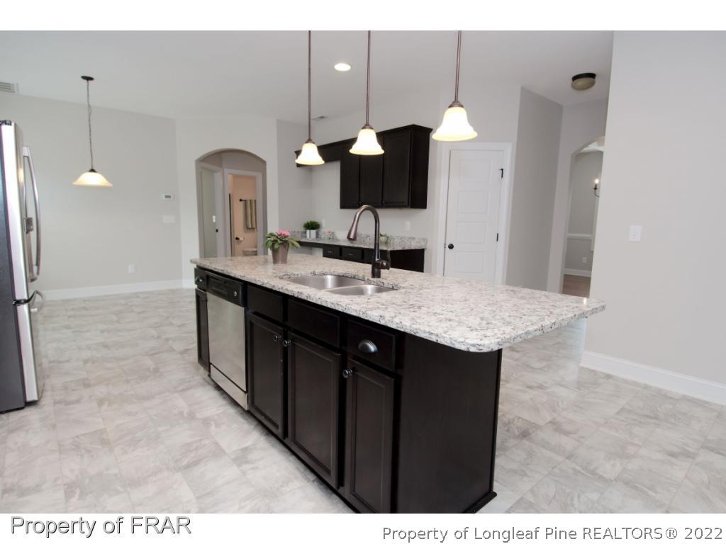 105 Caulfield Road Aberdeen, NC 28315 - Photo 8 of 36 a kitchen with a sink cabinets and chandelier