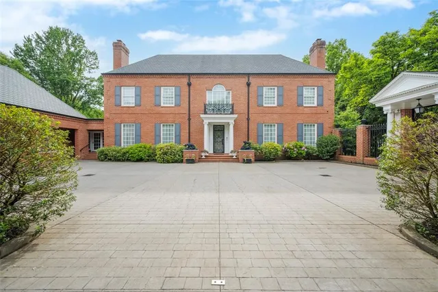 a front view of house with yard and trees around
