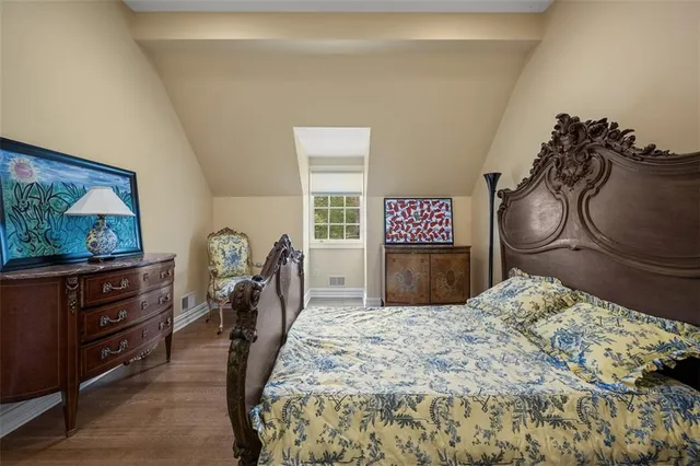 a bedroom with a bed and dresser with mirror