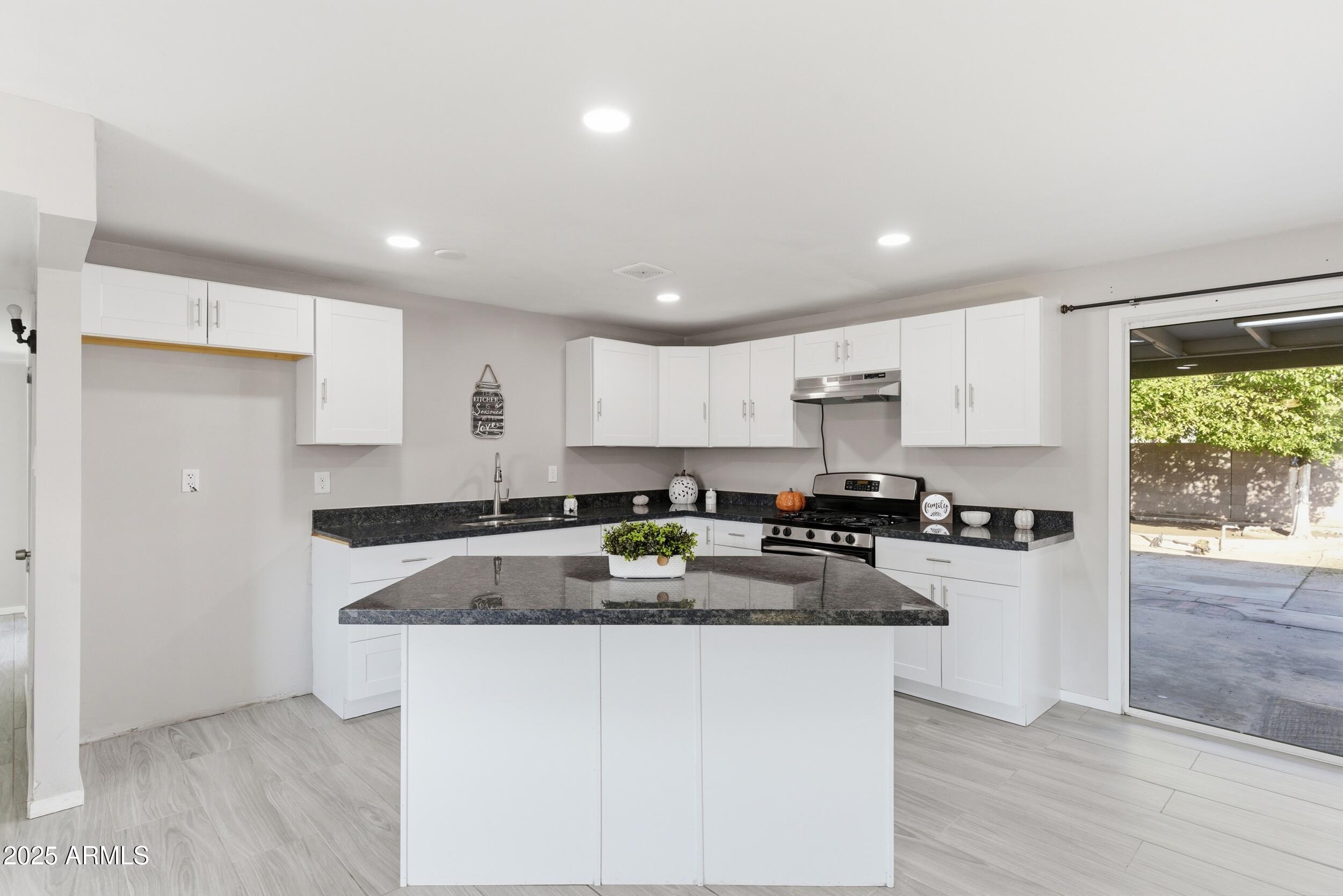 7150 West Montecito Avenue Phoenix, AZ 85033 - Photo 7 of 30 a kitchen with granite countertop white cabinets and refrigerator