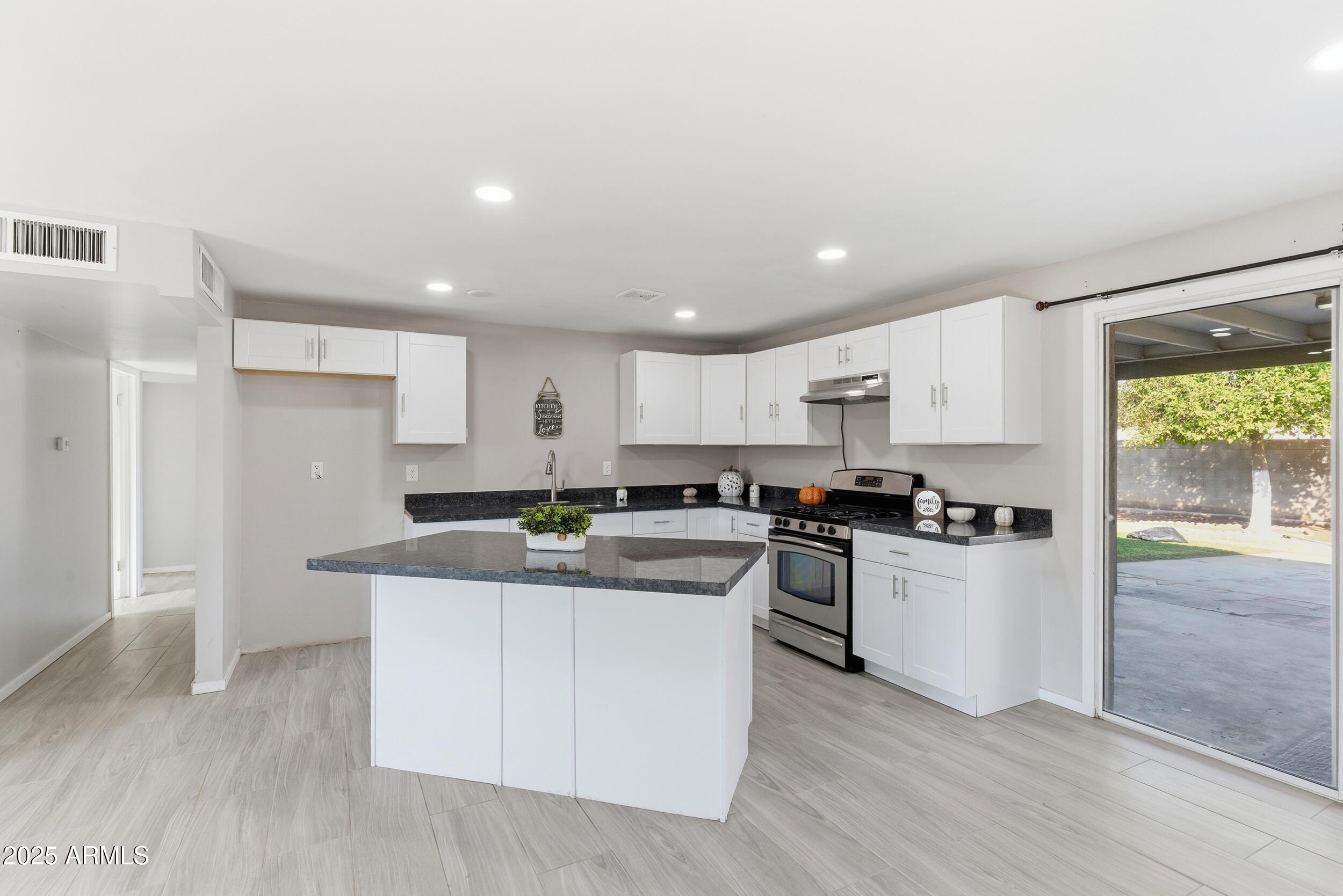 7150 West Montecito Avenue Phoenix, AZ 85033 - Photo 9 of 30 a kitchen with stainless steel appliances kitchen island granite countertop a stove and a refrigerator