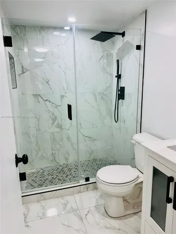 a bathroom with a toilet and a shower