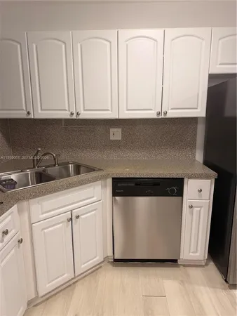 a kitchen with white cabinets and white appliances