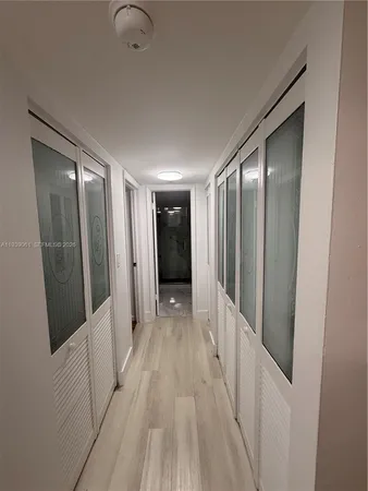 a view of a hallway with wooden floor