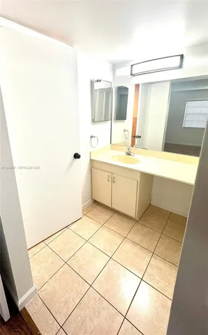 a large white tub with glass door shower and a sink