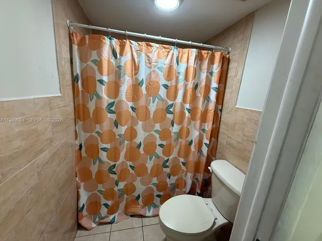 a white toilet sitting next to a shower curtain