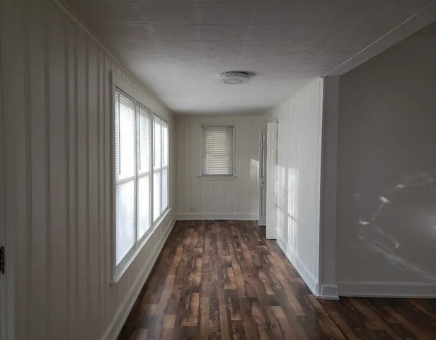 a view of a room with wooden floor and windows