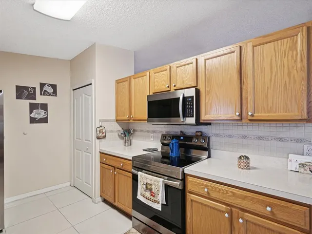 a kitchen with stainless steel appliances granite countertop a sink a stove and a microwave