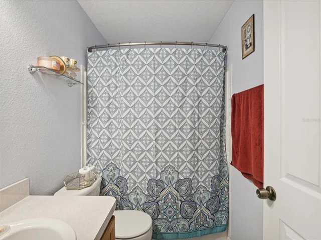 a bathroom with a toilet and a shower curtain