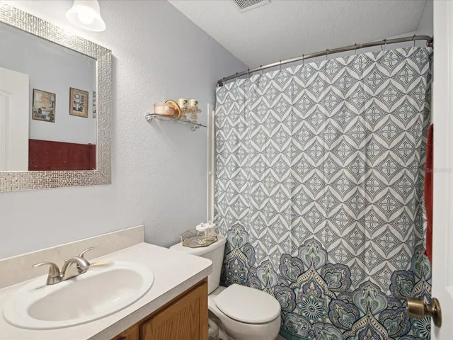 a bathroom with a sink mirror vanity and toilet