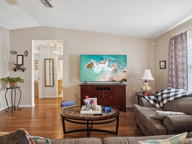 a living room with furniture and a wooden floor
