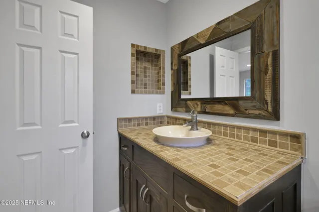 a bathroom with a granite countertop sink toilet a mirror and shower