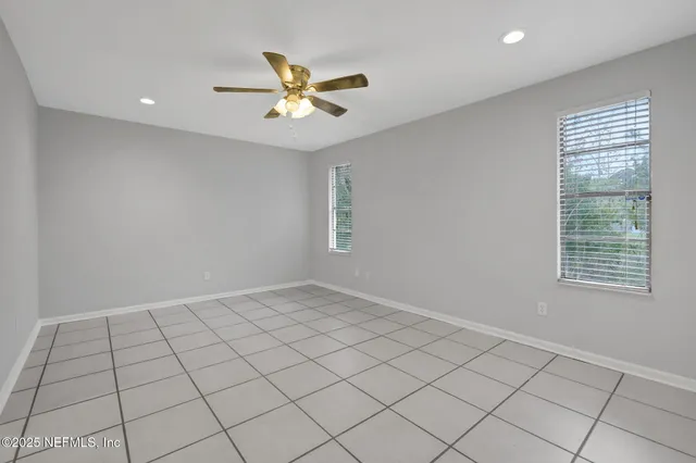 an empty room with a ceiling fan and a window