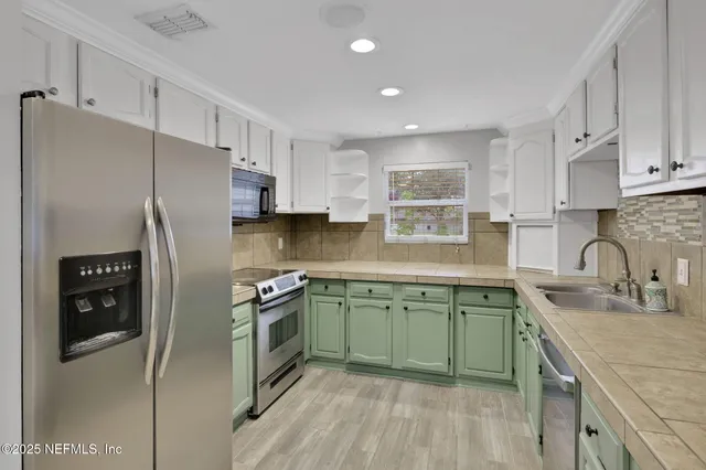 a kitchen with stainless steel appliances granite countertop white cabinets sink and dishwasher