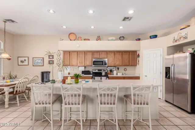 a kitchen with stainless steel appliances kitchen island granite countertop a refrigerator and a stove top oven