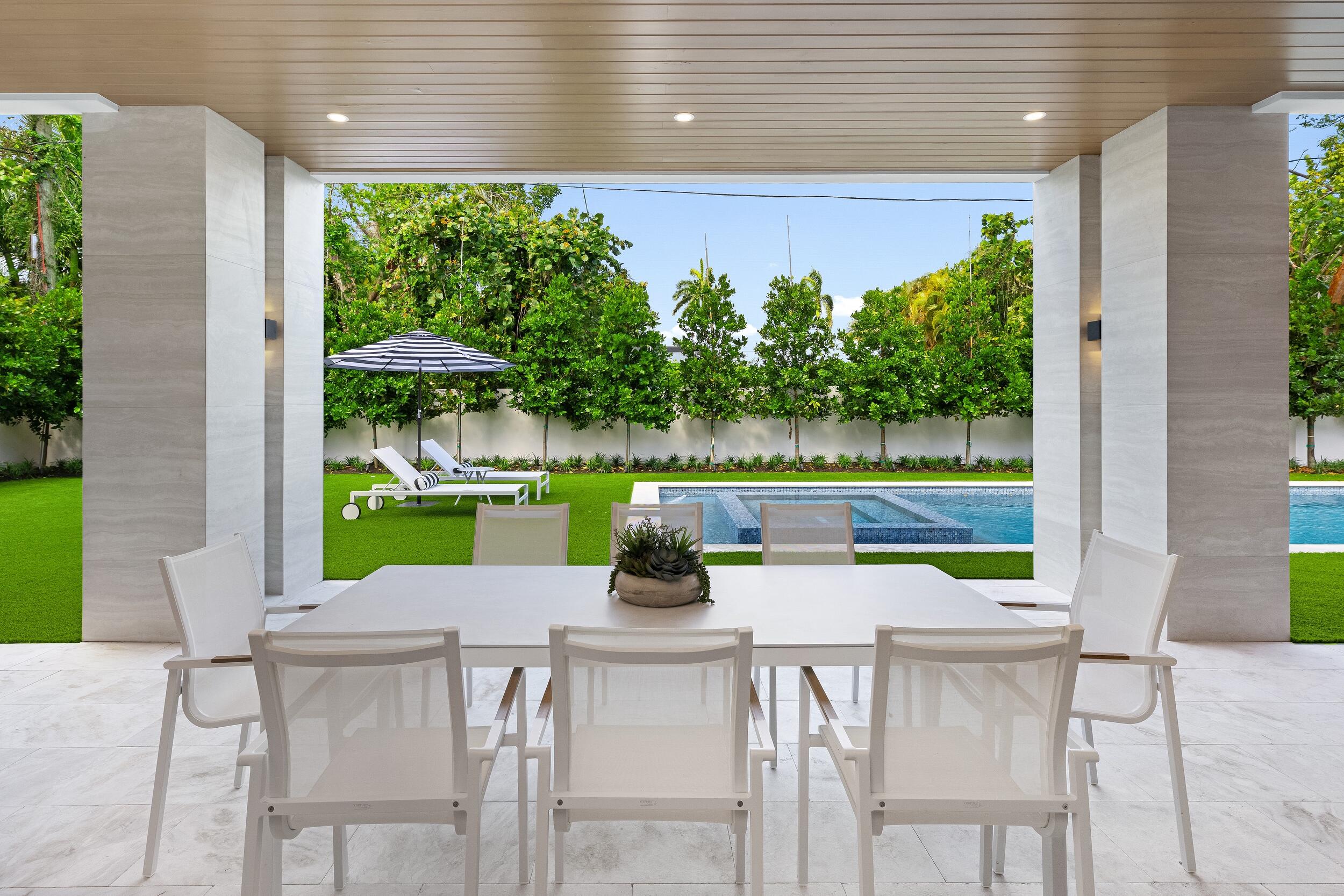 1351 Cocoanut Road Boca Raton, FL 33432 - Photo 47 of 101 a view of a chairs and table in patio with a yard