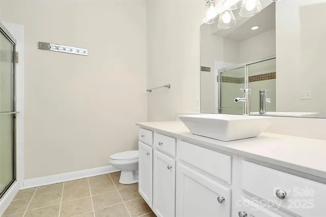 a bathroom with a granite countertop sink a toilet and a mirror