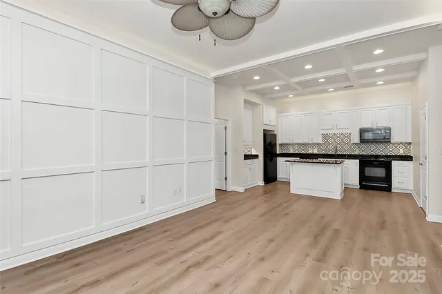 a view of kitchen with granite countertop cabinets and refrigerator