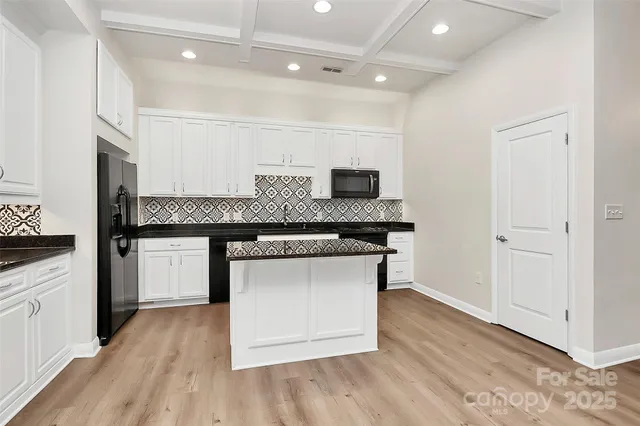 a kitchen with granite countertop a sink cabinets and stainless steel appliances