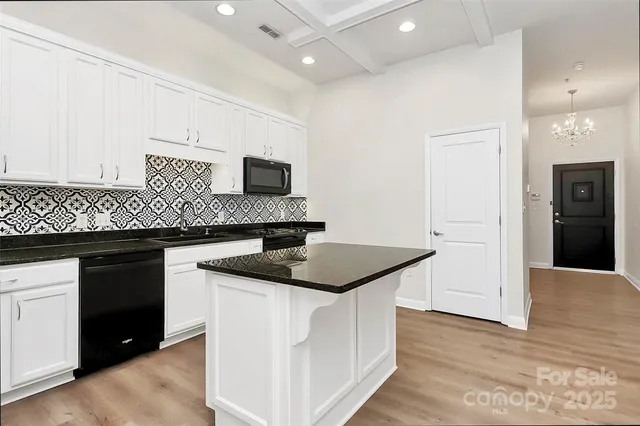 a kitchen with stainless steel appliances granite countertop a sink and a refrigerator