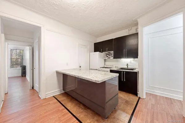 a kitchen with stainless steel appliances kitchen island granite countertop a sink stove and refrigerator