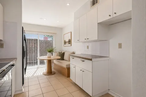 a kitchen with white cabinets and white appliances