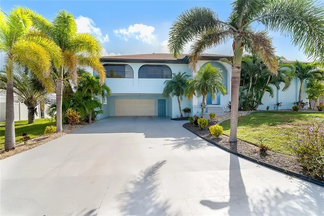 a view of a house with a yard and palm trees