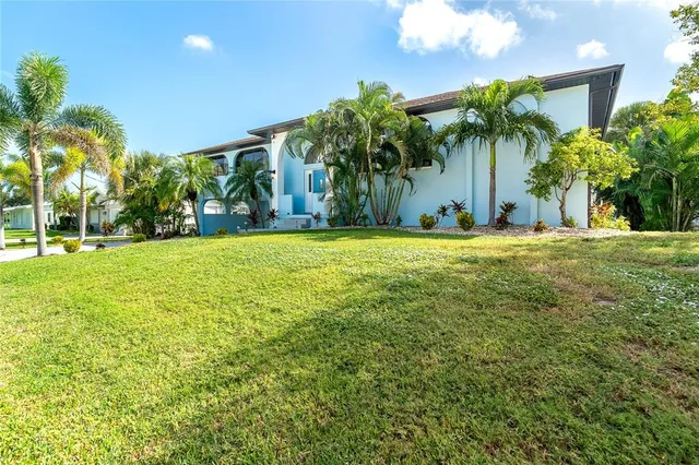 a front view of a house with a yard and palm trees