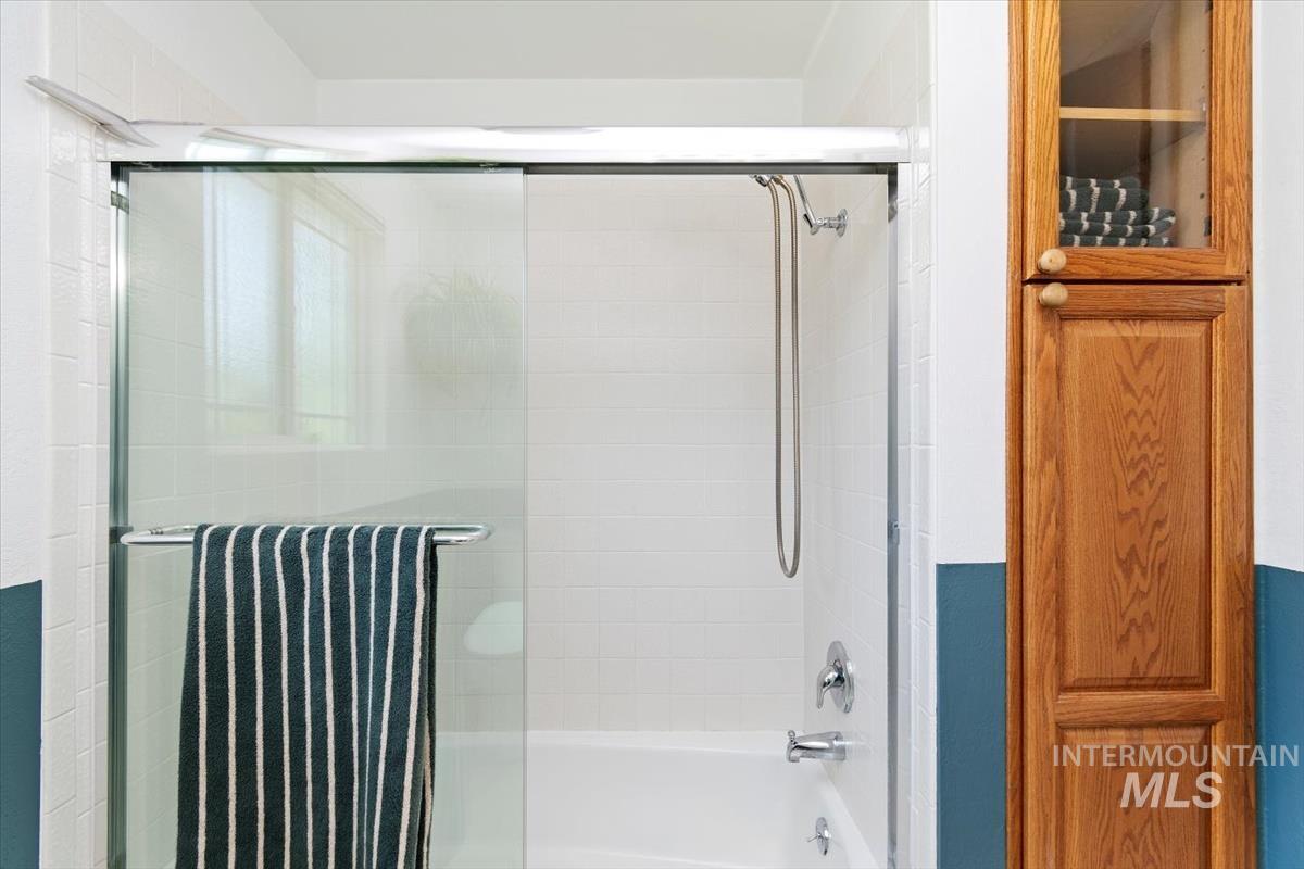 10178 West Fox Ridge Drive Boise, ID 83709 - Photo 16 of 36 White tiled shower with sliding glass enclosure and chrome fixtures