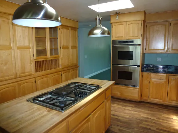 a kitchen with stainless steel appliances granite countertop a stove a sink and a refrigerator