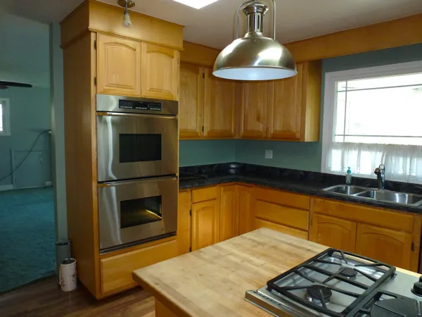 a kitchen with stainless steel appliances a stove a refrigerator and a sink