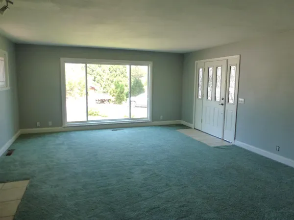 an empty room with windows and fireplace