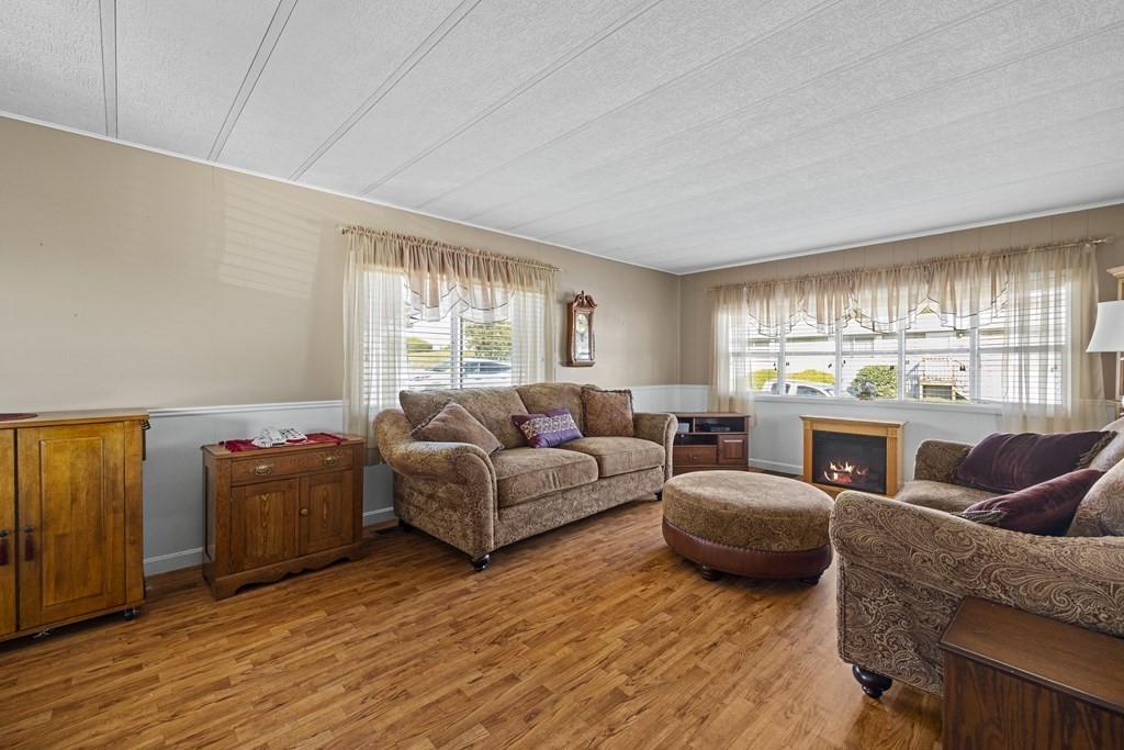 a living room with furniture a fireplace and a large window