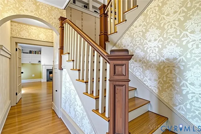 a view of a hallway with wooden floor and staircase
