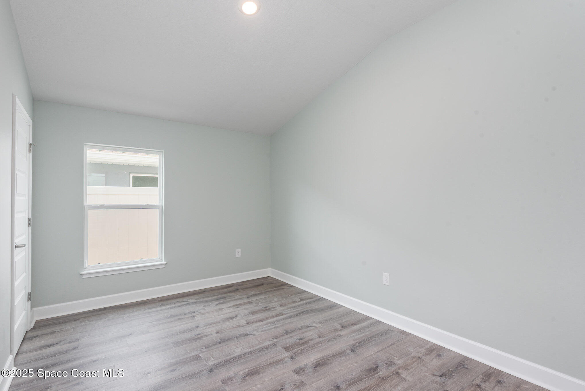 1331 Tupelo Circle Cocoa, FL 32926 - Photo 15 of 29 an empty room with wooden floor and window