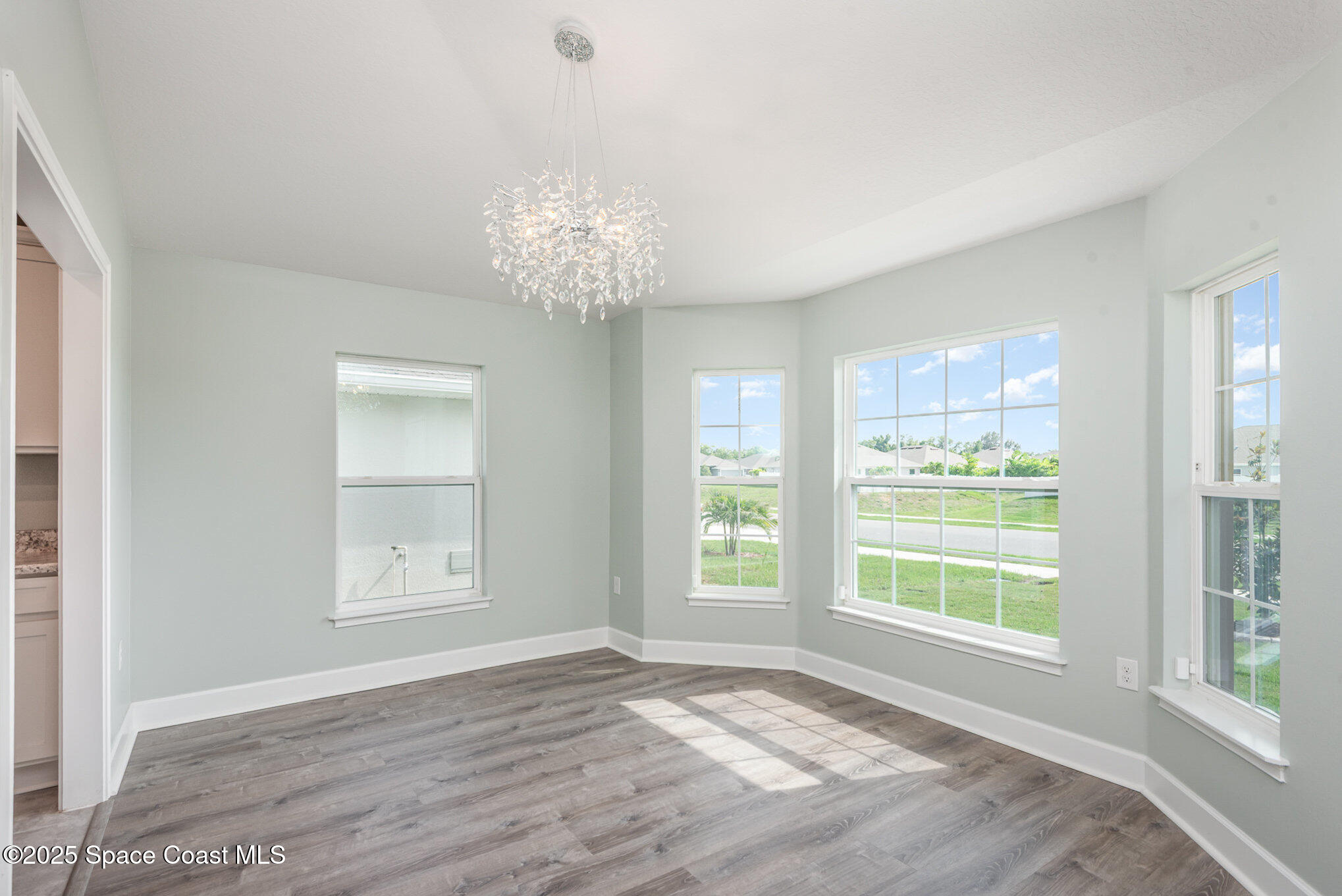 1331 Tupelo Circle Cocoa, FL 32926 - Photo 9 of 29 a view of an empty room with wooden floor and a window