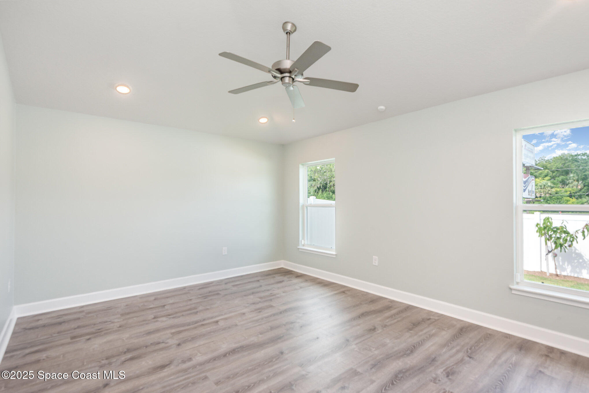 1331 Tupelo Circle Cocoa, FL 32926 - Photo 10 of 29 an empty room with wooden floor window and ceiling fan