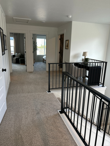 2011 West 1150 South, Unit 1042 Payson, UT 84651 - Photo 34 of 39 Photos are of model home.Carpeted hallway with white walls and trim, featuring black metal stair railings
