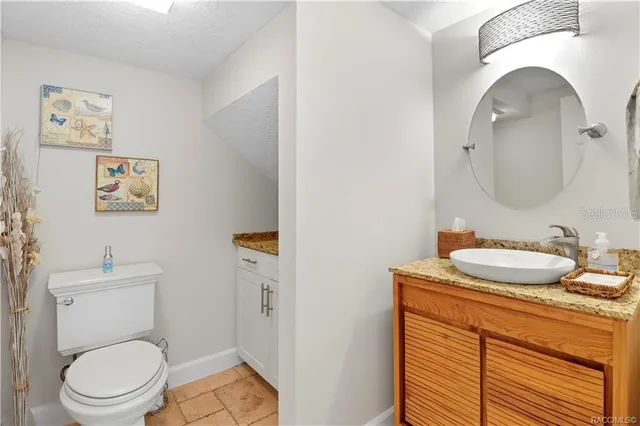 a spacious bedroom with a bed a dresser and a chandelier