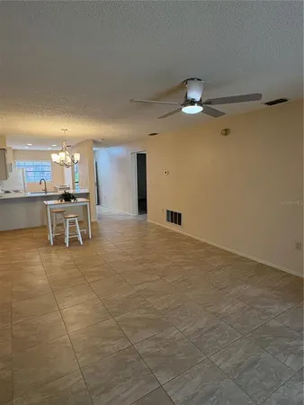 a view of an empty room with a floor to ceiling window and a ceiling fan