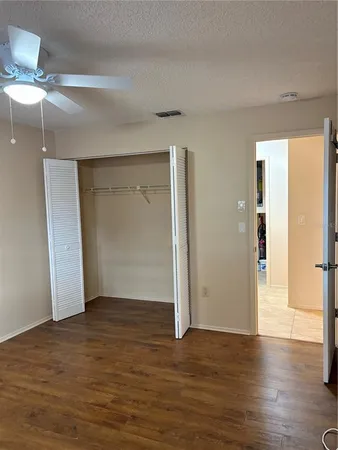 a view of an empty room with wooden floor fireplace and a window