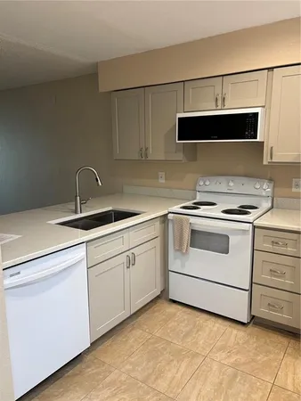 a kitchen with white cabinets appliances and sink