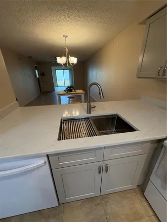 a kitchen with white cabinets and sink