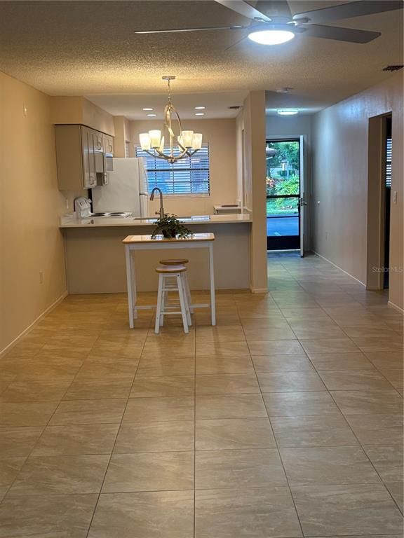 13250 Ridge Road, Unit 16 Largo, FL 33778 - Photo 5 of 36 a view of a kitchen with kitchen island granite countertop a sink a counter top space appliances and cabinets