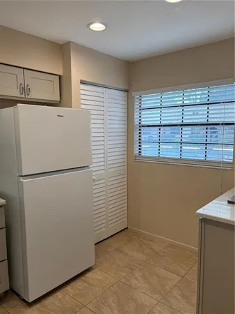 a view of kitchen with refrigerator cabinets and wooden floor