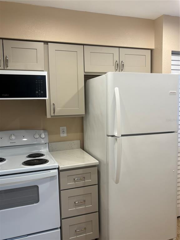 13250 Ridge Road, Unit 16 Largo, FL 33778 - Photo 8 of 36 a white refrigerator freezer and a stove sitting inside of a kitchen